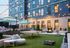 Chic outdoor patio with elegant string lights, stylish lounge chairs, and a modern ping pong table, offering a perfect blend of relaxation and entertainment.