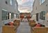 Contemporary outdoor seating area with elegant wicker furniture and ambient lighting, perfect for relaxation in a modern apartment complex.