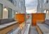 Modern urban courtyard with sleek firepit, cozy seating, and stylish wooden privacy panels, perfect for relaxation.