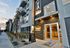 Modern apartment building exterior with stylish entrance and leasing office at sunset, highlighted by sleek design and inviting ambiance.