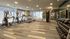 Modern fitness center with state-of-the-art treadmills, multi-exercise machine, and a complete set of weights with mirrors enhancing the spacious and inviting atmosphere.