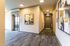 Modern apartment hallway with sleek elevator, contemporary artwork, and warm lighting.