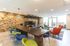 Modern apartment lobby with vibrant chairs, stylish wooden wall, and cozy seating area.