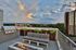 Luxurious rooftop terrace featuring a cozy fire pit, modern outdoor seating, and stunning cityscape views.