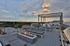 Sophisticated rooftop terrace featuring modern outdoor seating, a cozy fire pit, and panoramic city views under a breathtaking sunset sky.
