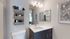 Sleek modern bathroom featuring elegant vanity with ample storage and chic wall-mounted towel organizer.