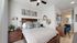 Inviting bedroom with chic decor, featuring a cozy bed with patterned cushions, ambient lighting, and elegant wooden furniture.