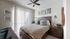 Bright and inviting bedroom with modern decor, featuring a stylish wooden bed, plush pillows, and ambient lighting.