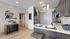 Modern apartment kitchen with sleek dark cabinets, stainless steel appliances, and cozy dining area with stylish decor.