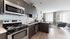 Modern open-plan kitchen and living area with sleek cabinetry, stainless steel appliances, and elegant decor.