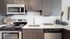 Modern kitchen with stainless steel appliances, elegant cabinetry, and a sleek white countertop.