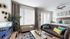 Chic open-plan living area with modern sofa, bright decor, and large windows letting in natural light.