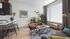 Chic and modern living room with stylish furniture, natural light, vibrant decor, and a cozy ambiance.