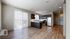 Bright and modern open-concept kitchen and living area with stainless steel appliances and elegant hardwood floors.