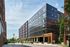 Modern apartment complex featuring sleek, contemporary design with large windows and lush greenery, highlighting urban living with charm and style.