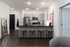 Modern apartment kitchen with sleek stainless-steel appliances, chic bar seating, and elegant decor.