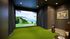 Luxurious indoor golf simulator room with state-of-the-art widescreen display, elegant decor, and golf equipment, perfect for avid golfers seeking a refined experience at home.