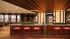 Chic and modern lounge area with stylish red bar stools, warm lighting, and vibrant decor.