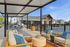Chic outdoor seating area with modern furniture overlooking a sparkling pool and stylish clubhouse.