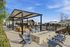 Inviting outdoor area with modern seating, stylish pergola, and a cozy fire pit overlooking a sparkling community pool.