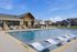 Inviting outdoor pool with modern lounge chairs surrounded by scenic housing, perfect for relaxation and leisure.