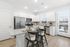 Modern kitchen with sleek white cabinetry, granite countertops, stainless steel appliances, and a breakfast bar with stylish seating.