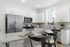 Contemporary kitchen with sleek stainless steel appliances, granite countertops, and white cabinetry creating a bright, inviting space.