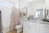 Bright and modern bathroom featuring sleek granite countertops, stylish white cabinetry, and a cozy shower area, perfect for relaxation.
