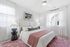 Bright and inviting bedroom featuring a cozy bed with soft linens, elegant bedside lamps, and modern wall art, creating a serene ambiance.