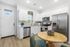 Bright and modern kitchen with stainless steel appliances, sleek white cabinetry, and a charming dining area, perfect for cozy meals.