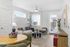 Chic and modern living room with natural light, featuring a stylish couch, elegant coffee table, and cozy dining area.