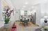 Modern open kitchen with sleek white cabinets, stainless steel appliances, and a cozy dining area with stylish decor and natural light.