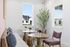 Charming dining nook with large windows, elegant tables, and cozy seating, perfect for intimate gatherings.