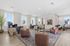 Chic living area with modern furniture, elegant decor, natural light, and a sophisticated office setup.