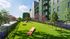 Lush green outdoor area featuring vibrant landscaping and pet-friendly exercise zone beside stylish modern apartment facade.