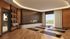 Elegant yoga studio boasting warm wooden floors, ambient lighting, and a cozy fireplace with lush outdoor views.