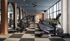 Modern gym with sleek cardio machines and weight equipment, featuring elegant wood accents and ample natural light.