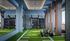 Modern gym room with sleek design, vibrant green turf flooring, and state-of-the-art fitness equipment.