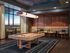 Elegant entertainment room with modern pool table, cozy seating, and ambient lighting, ideal for relaxation and socializing.