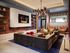 Elegant living room with a cozy sectional sofa, modern fireplace, and artistic lighting, perfect for relaxation and entertainment.