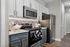 Modern kitchen with sleek stainless steel appliances, stylish cabinetry, and a chic tile backsplash, offering a blend of functionality and elegance.
