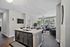 Modern apartment interior with a sleek open kitchen and bright living room, featuring stylish decor and large windows for natural light.