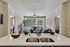 Bright and modern living area with stylish kitchen island, double sink, cozy seating, and large windows.