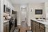 Modern kitchen with sleek stainless steel appliances, elegant cabinetry, and stylish countertops, featuring a cheerful sign that reads 'This Kitchen is for Dancing'.