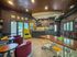 Chic communal lounge area featuring vibrant seating, modern bar stools, and a cozy ambiance with stylish decor.