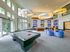 Elegant apartment lounge with modern pool table, plush blue seating, and large entertainment wall.