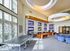 Bright and modern entertainment lounge with sleek decor, featuring comfortable seating, large windows, and a ping pong table for leisure.