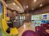 Chic and modern lounge area featuring vibrant purple and green seating, a stylish bar with contemporary decor, and expansive windows offering abundant natural light.