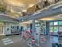 Modern fitness center with state-of-the-art equipment, bright interior, and loft-style architecture.