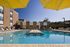 Inviting outdoor swimming pool area with modern amenities and sun loungers, perfect for relaxation and enjoyment under a clear blue sky.